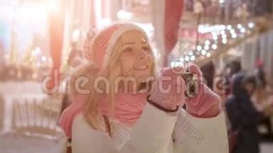 在冬天的雪夜，带着复古相机的年轻女子在圣诞市场